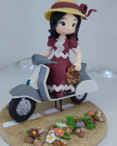 Miniatura de biscuit de mulher em scooter, de vestido vinho, em cena de primavera