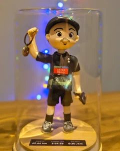 Boneco de biscuit corredor em miniatura, com medalha na mão e placa de recorde