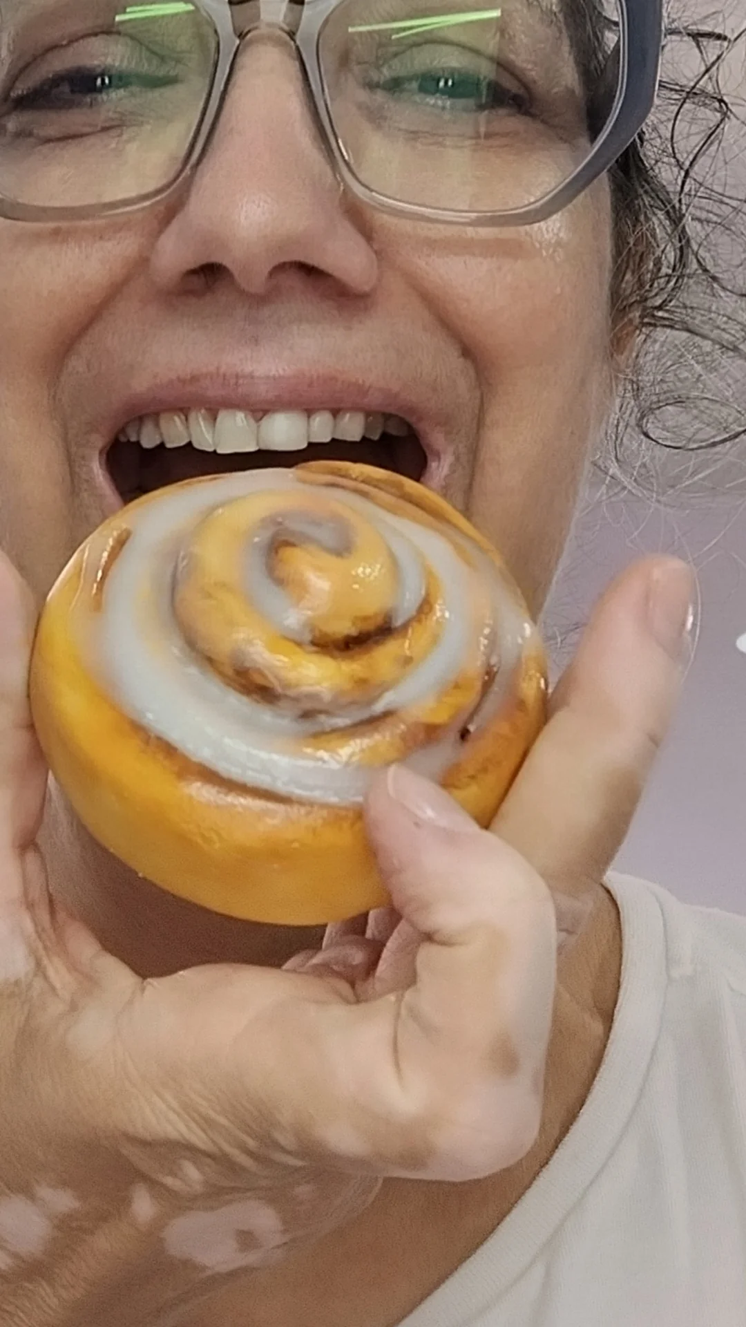 Mulher fingindo morder uma rosca de canela de biscuit